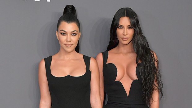 Kourtney Kardashian and sister Kim Kardashian wearing black dresses